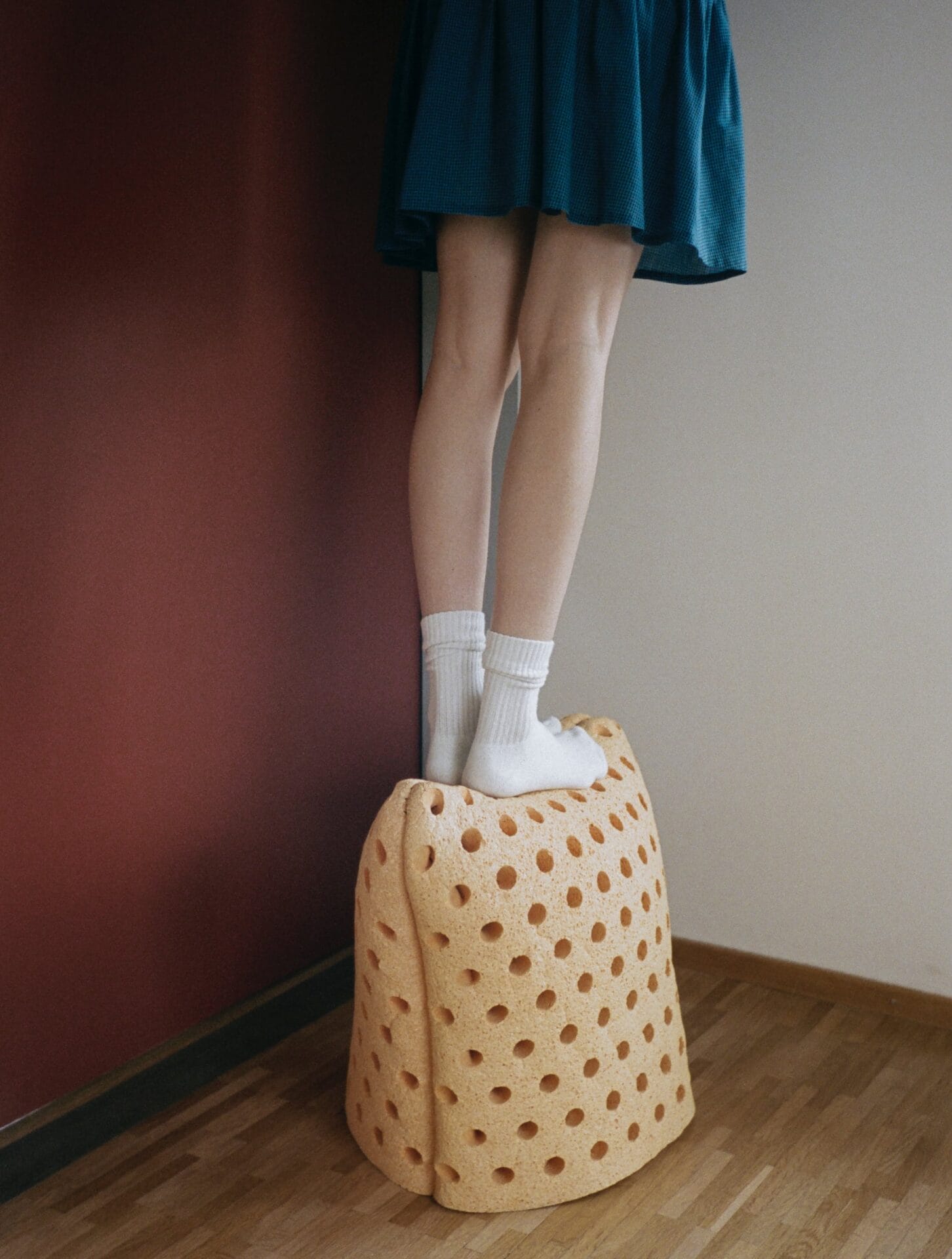 a person stands atop a sponge stool with holes 