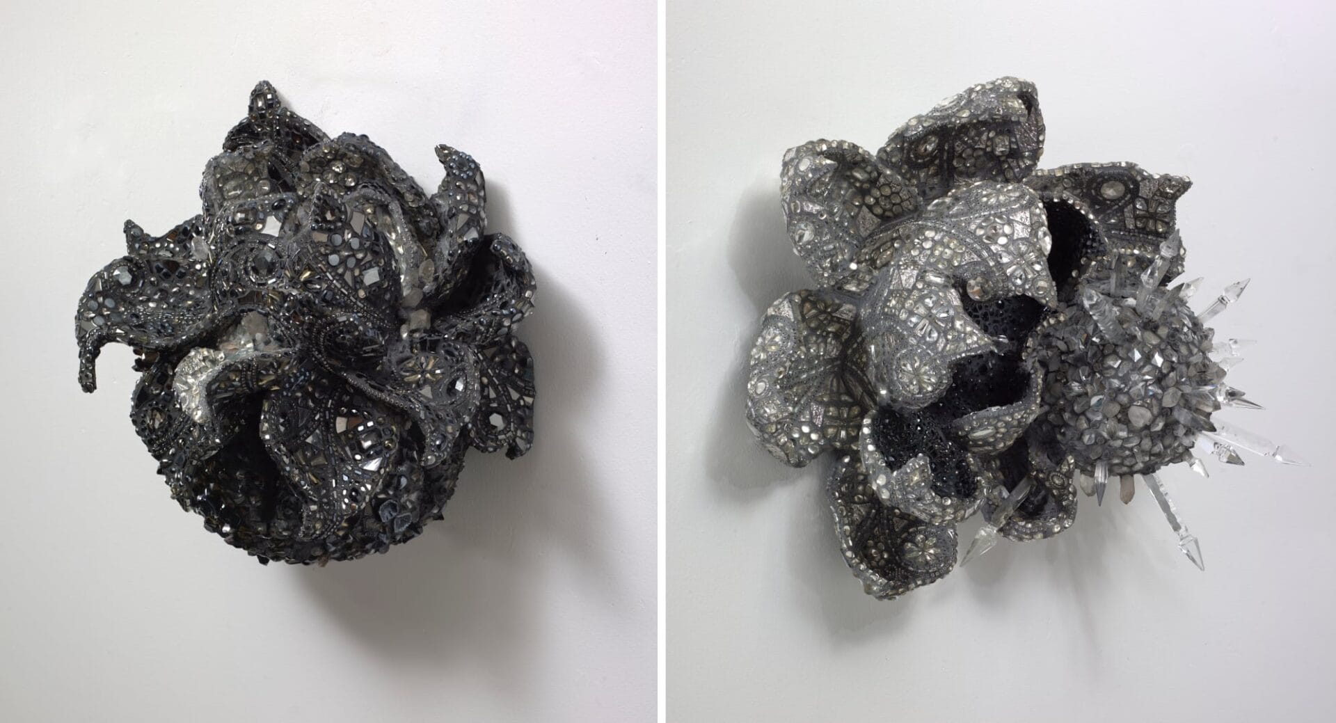 left: a black floral sculpture covered in mosaic tiles and glimmering crystals. right: right: a silver floral sculpture covered in mosaic tiles and glimmering crystals. 