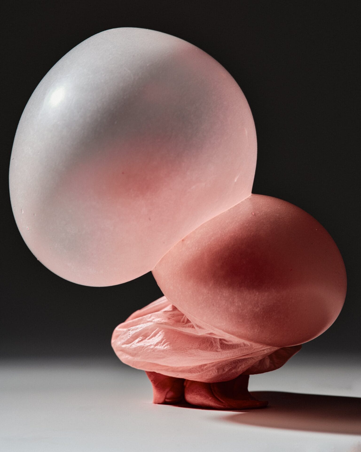 a photo of blown bubblegum with two pink bubbles at the top 