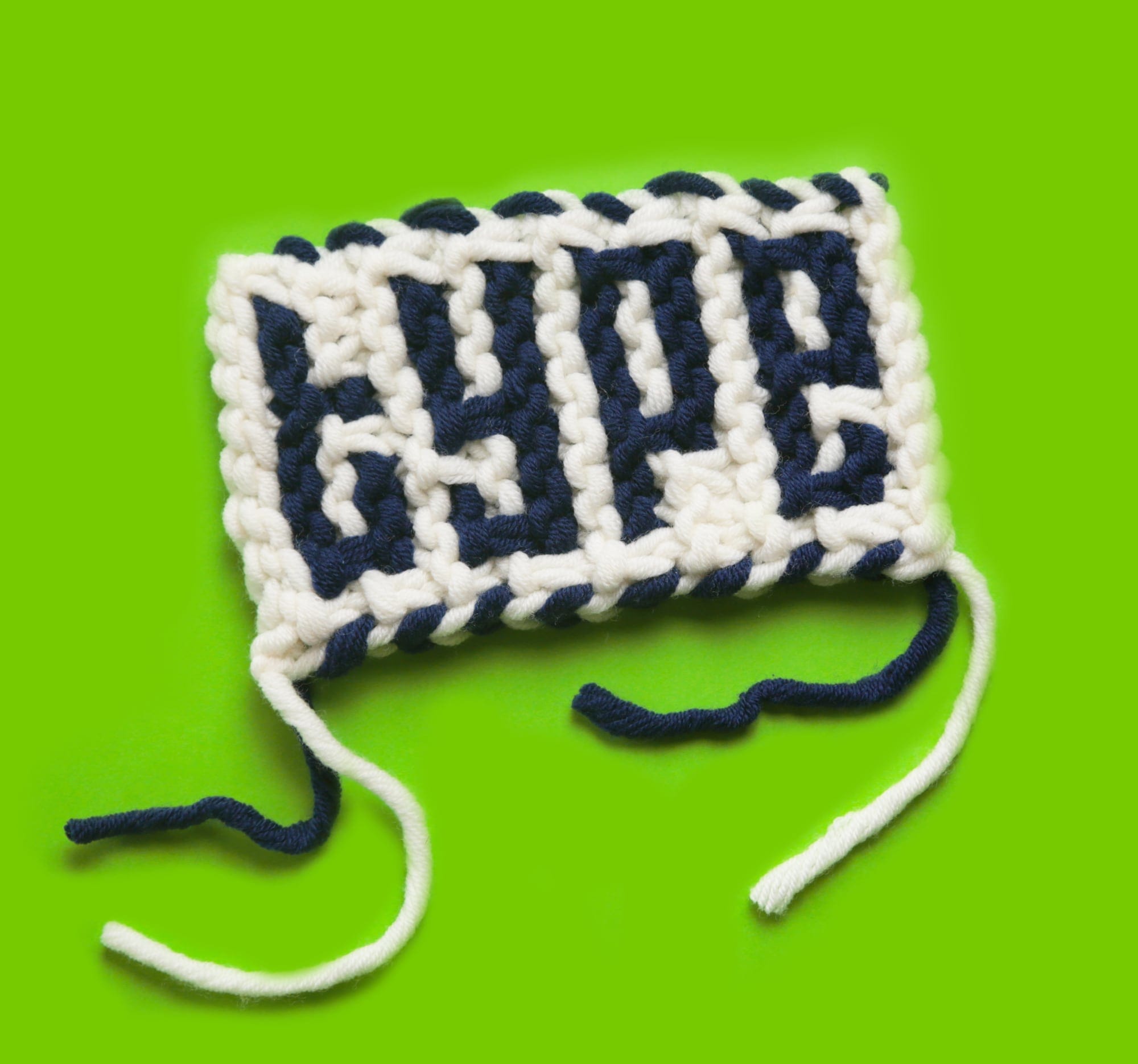 a small white and blue knit square that reads type