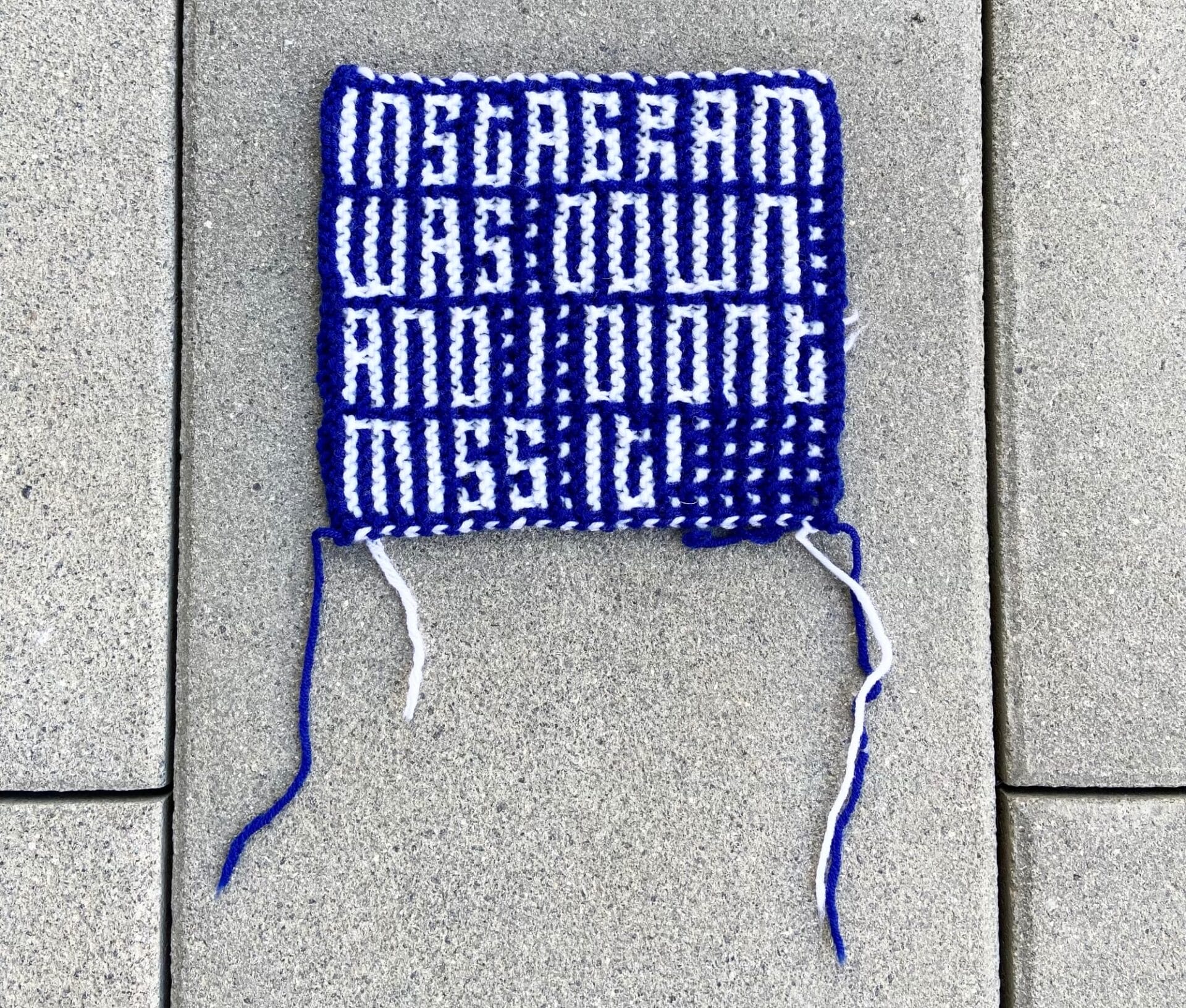 a blue and white knit square with text