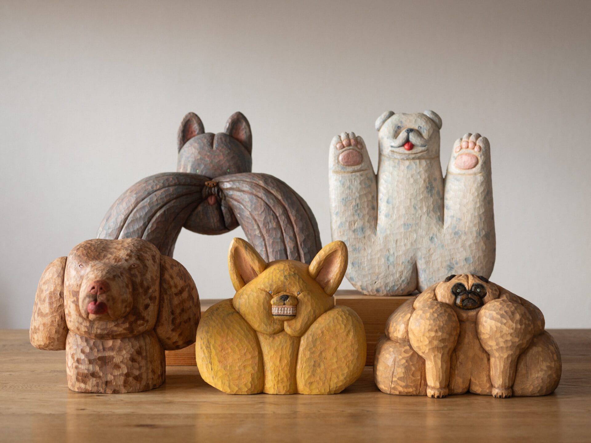 a collection of five quirky wooden sculptures of dogs