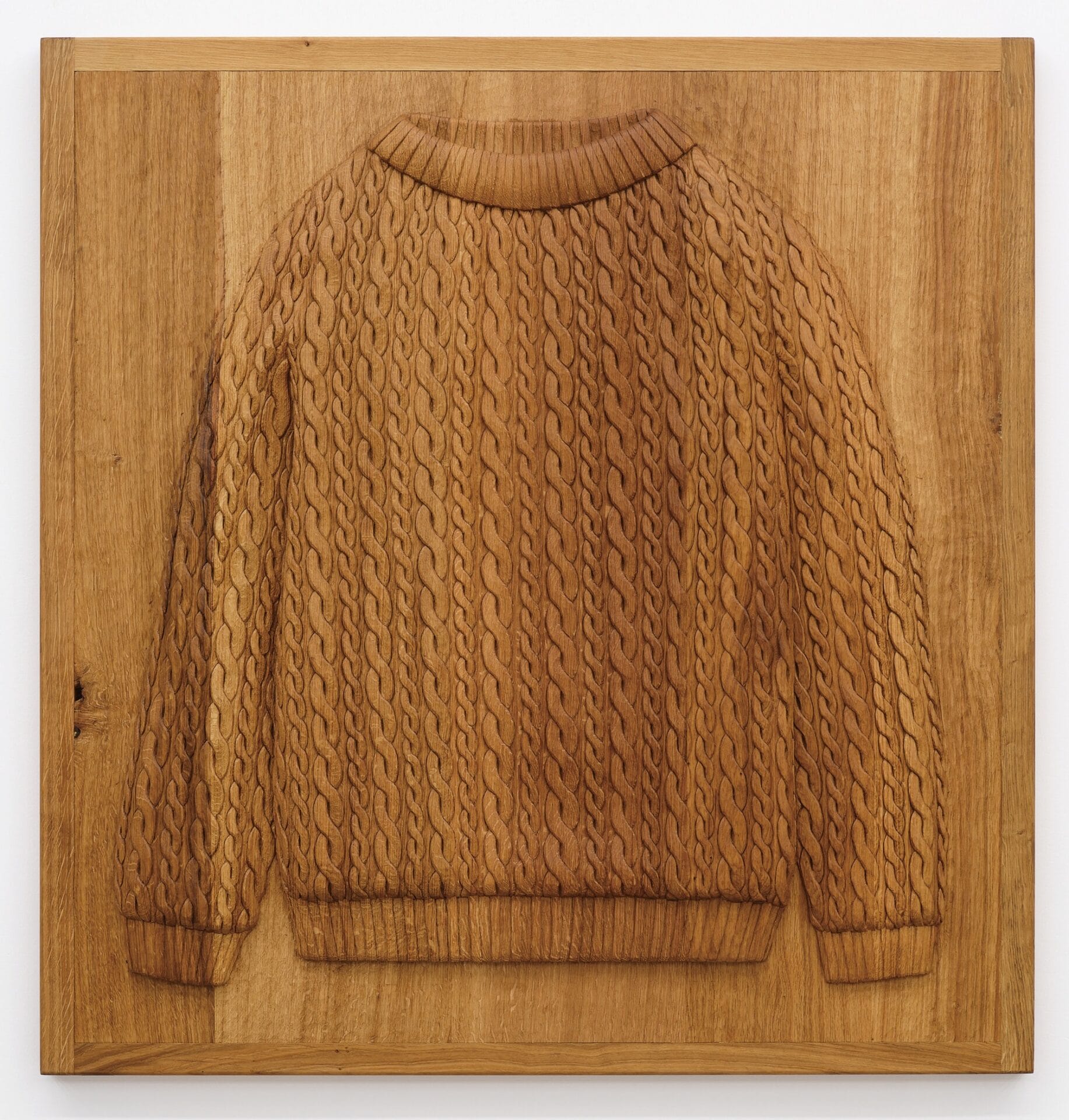 a wooden bas relief in oak of a knit sweater