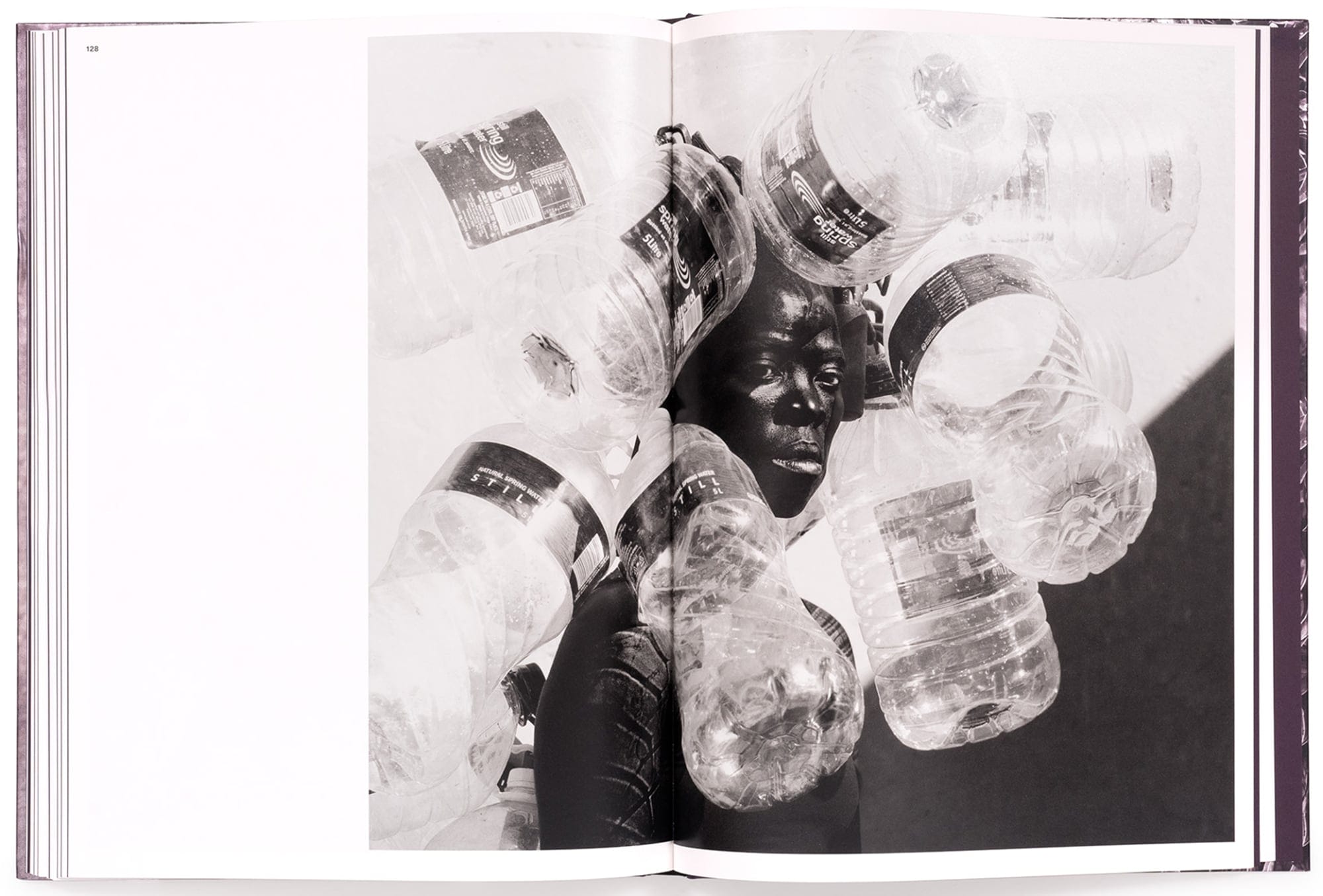 an open book spread with an image of the artist surrounded by water jugs
