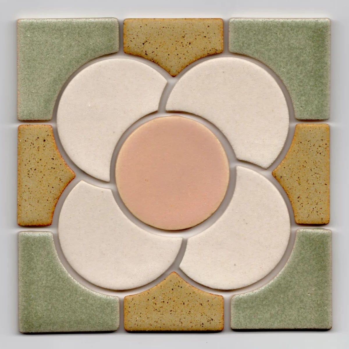 a square tile with a pink flower at the center and green and brown pieces around it