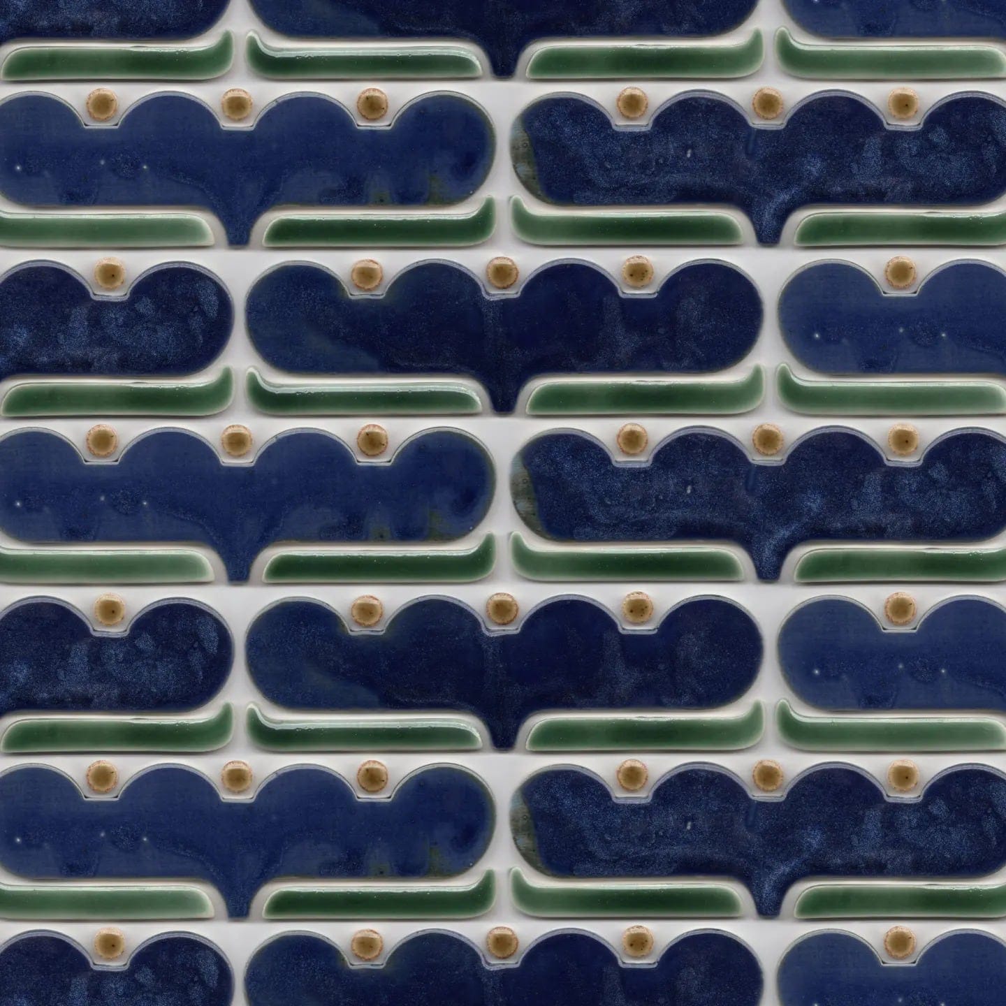 a mass of blue wavy tiles with brown dots in the bottom of the waves and green lines below the blue