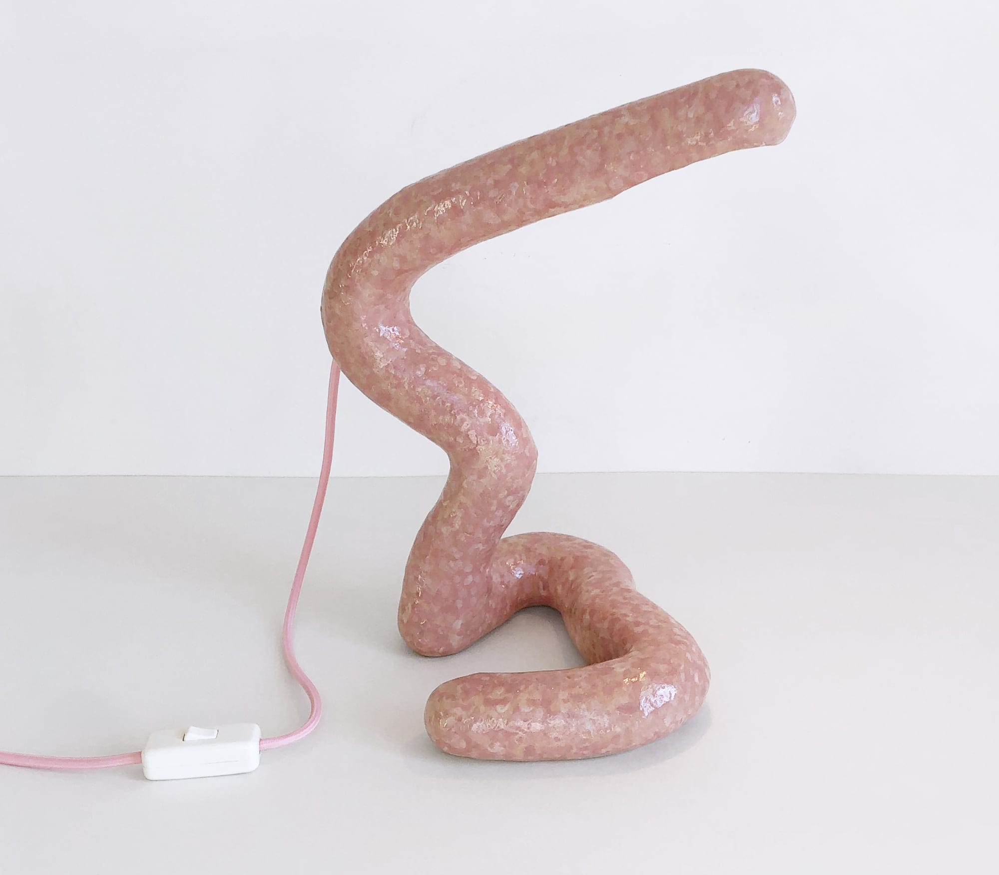 a large pink winding sausage lamp