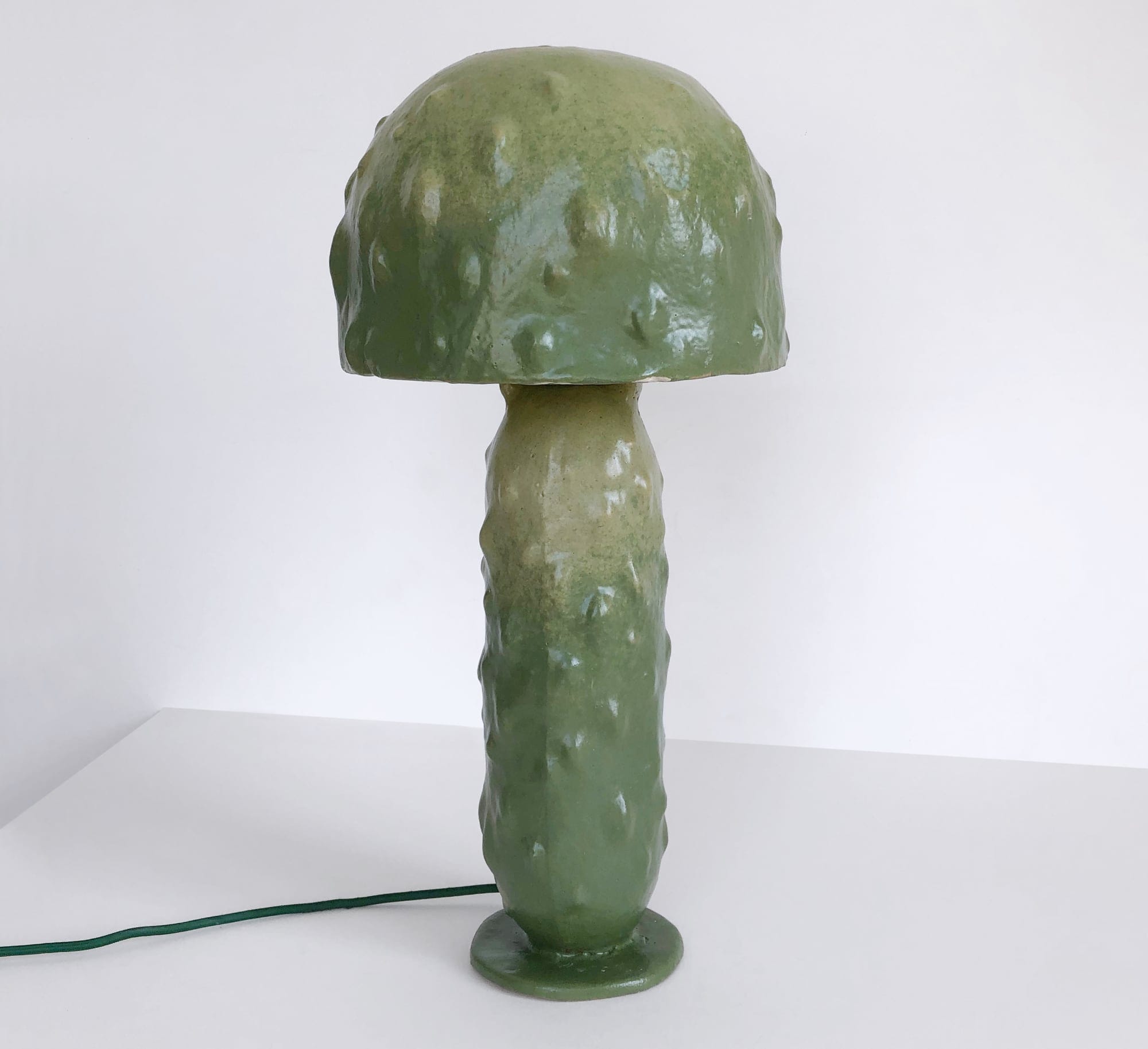 a large green ceramic pickle lamp