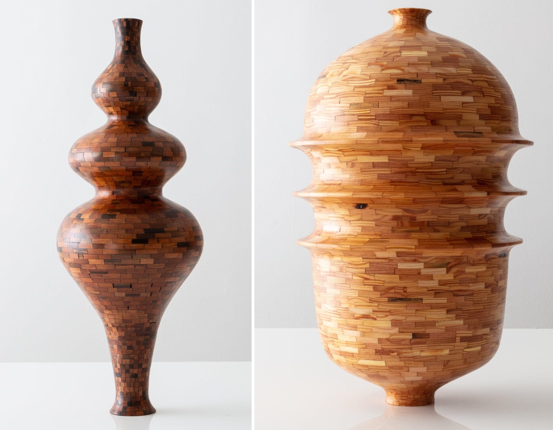 two curvy wooden vessels made of dark and light wood components fitted together