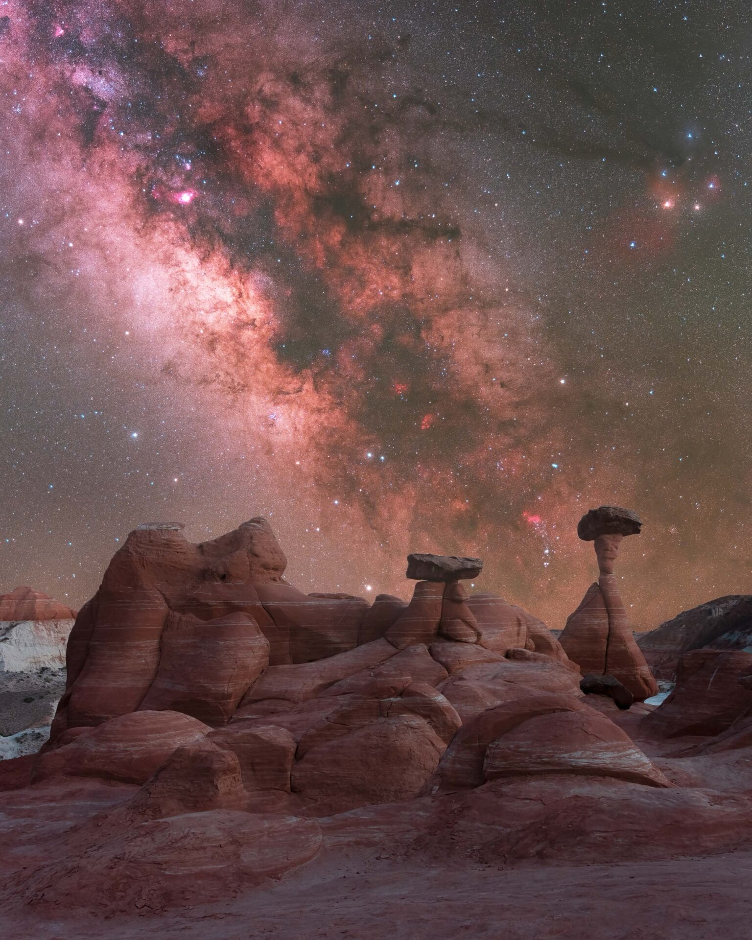 the brilliant star studded milky way above a desert with hoodoos