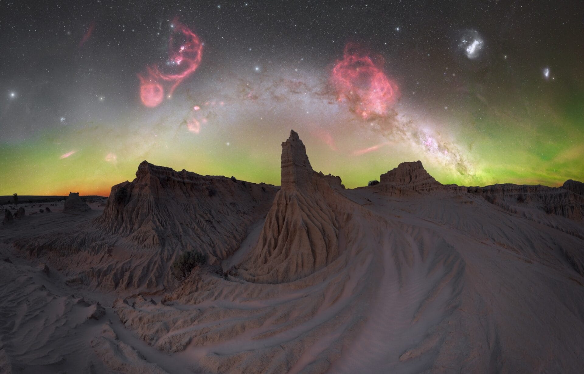 the brilliant star studded milky way above a desert landscape with hoodoos and sand