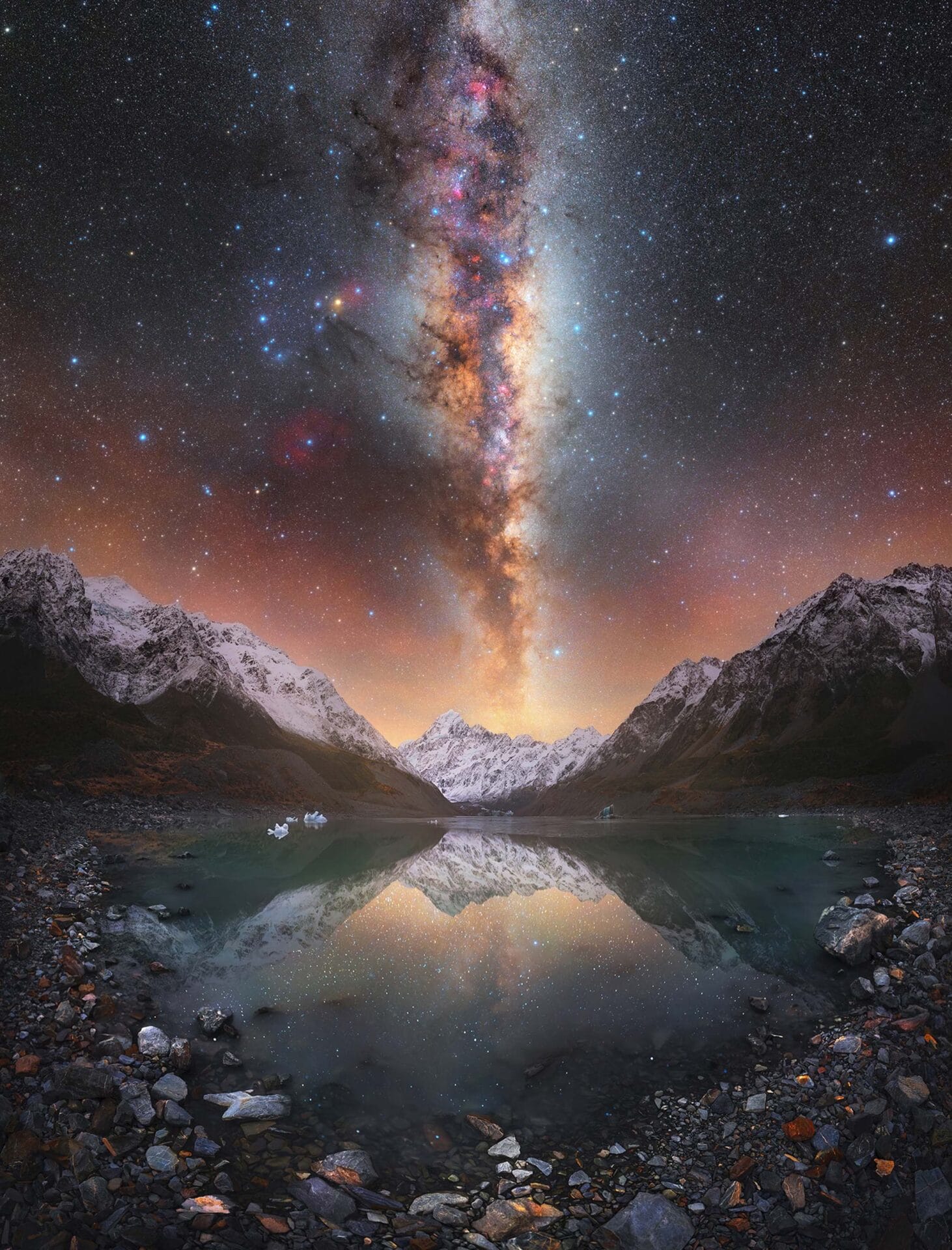 the brilliant star studded milky way above a lake with mountains in the background