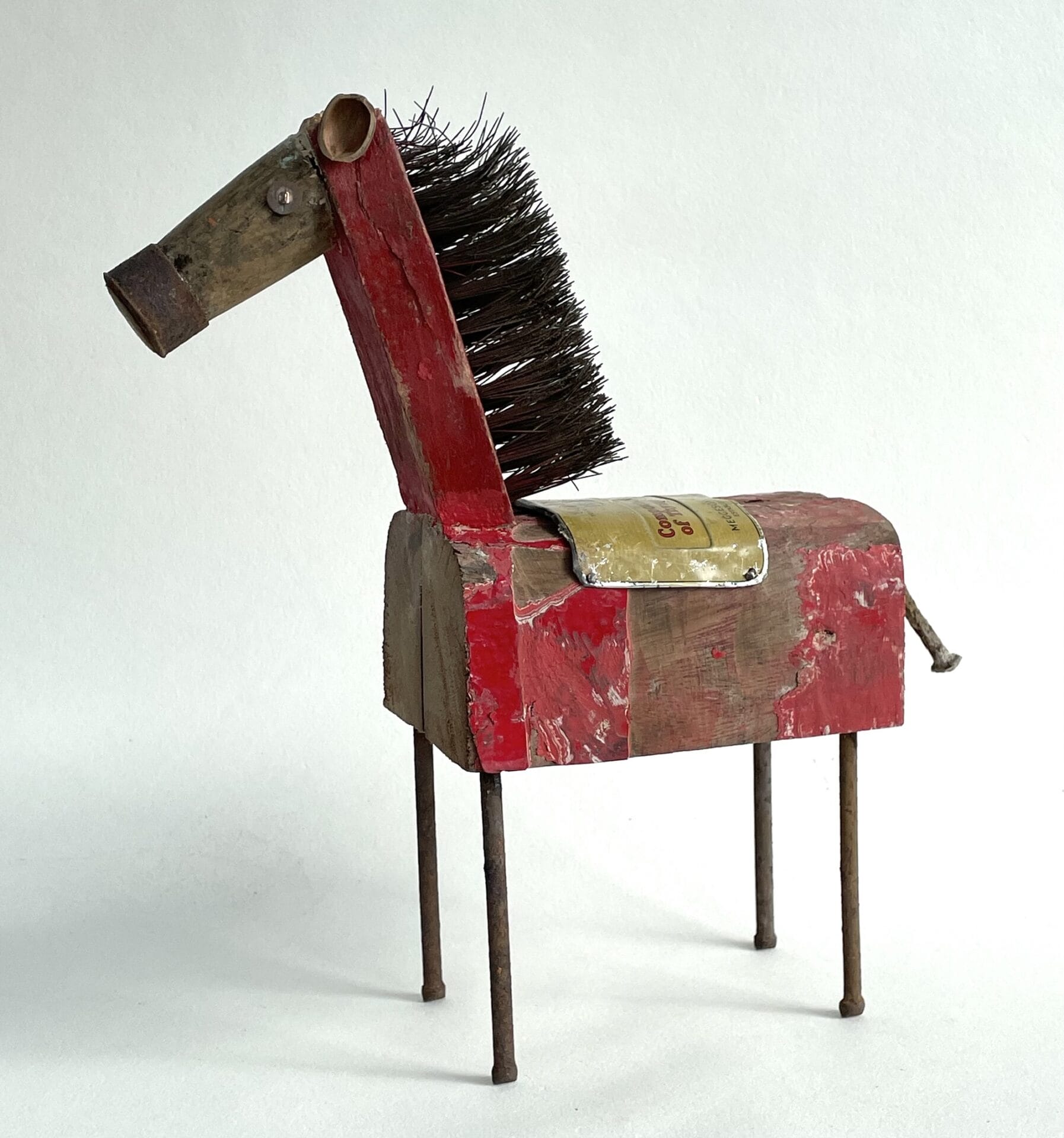 a sculpture of a horse made from an old brush and repurposed wood and nails