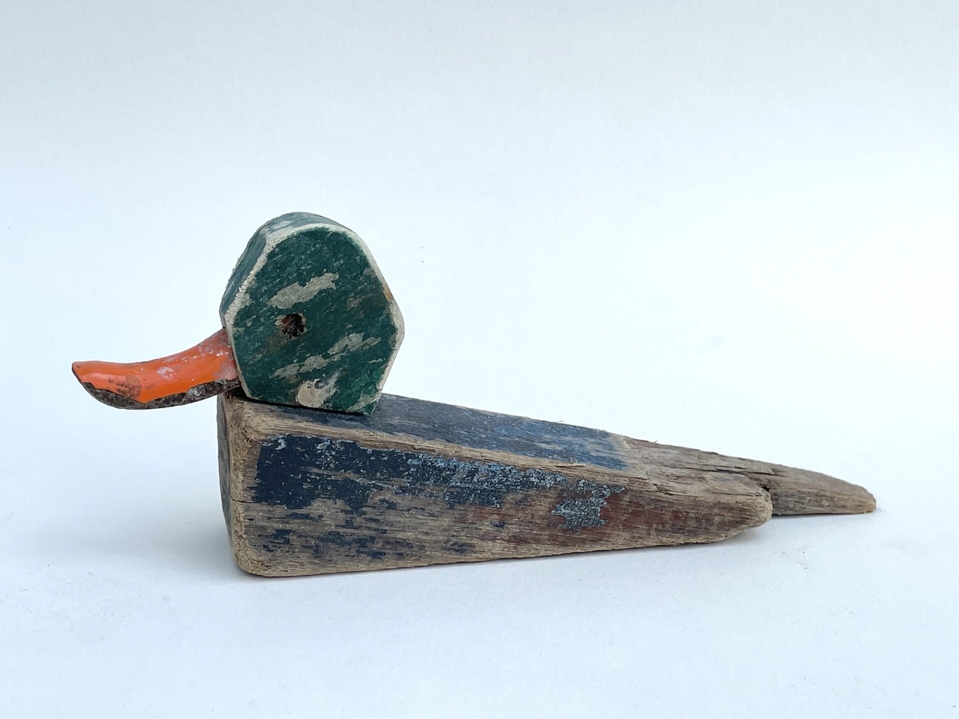 a small wooden sculpture of a mallard duck made from repurposed found materials