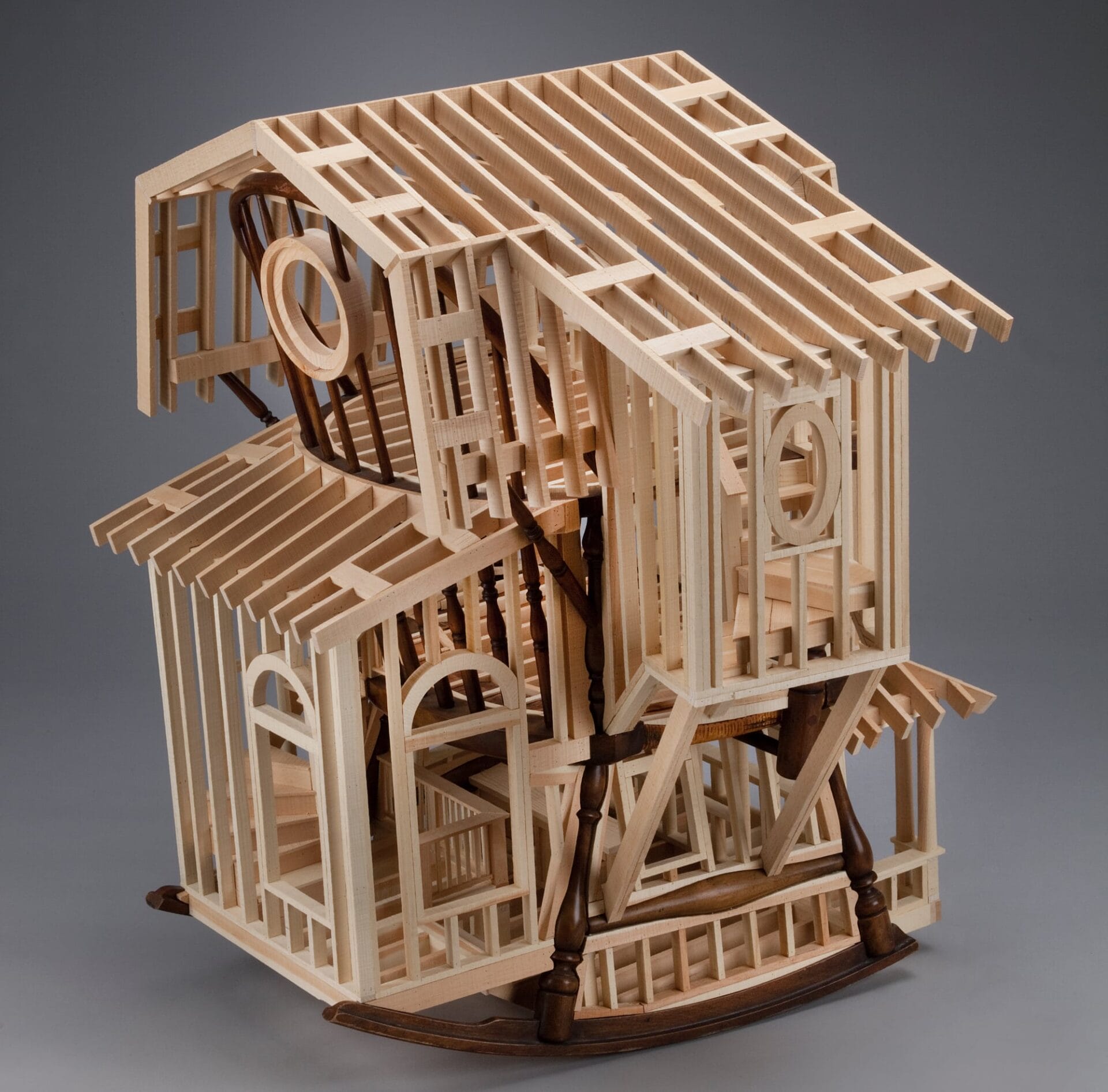 a wooden house frame is built around a child's rocking chair 