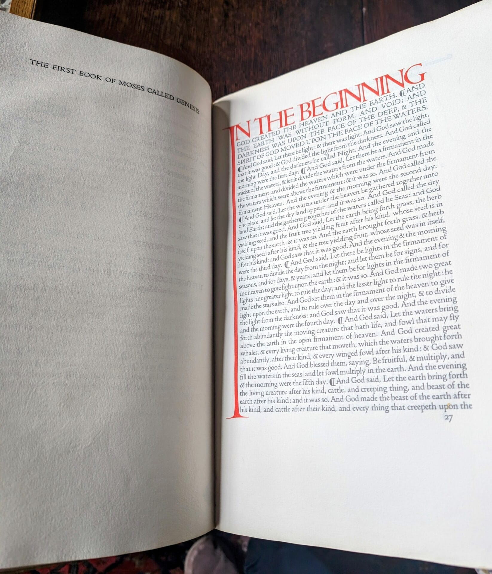 a bible printed with Doves Type, with the words "in the beginning" bright red capital letters