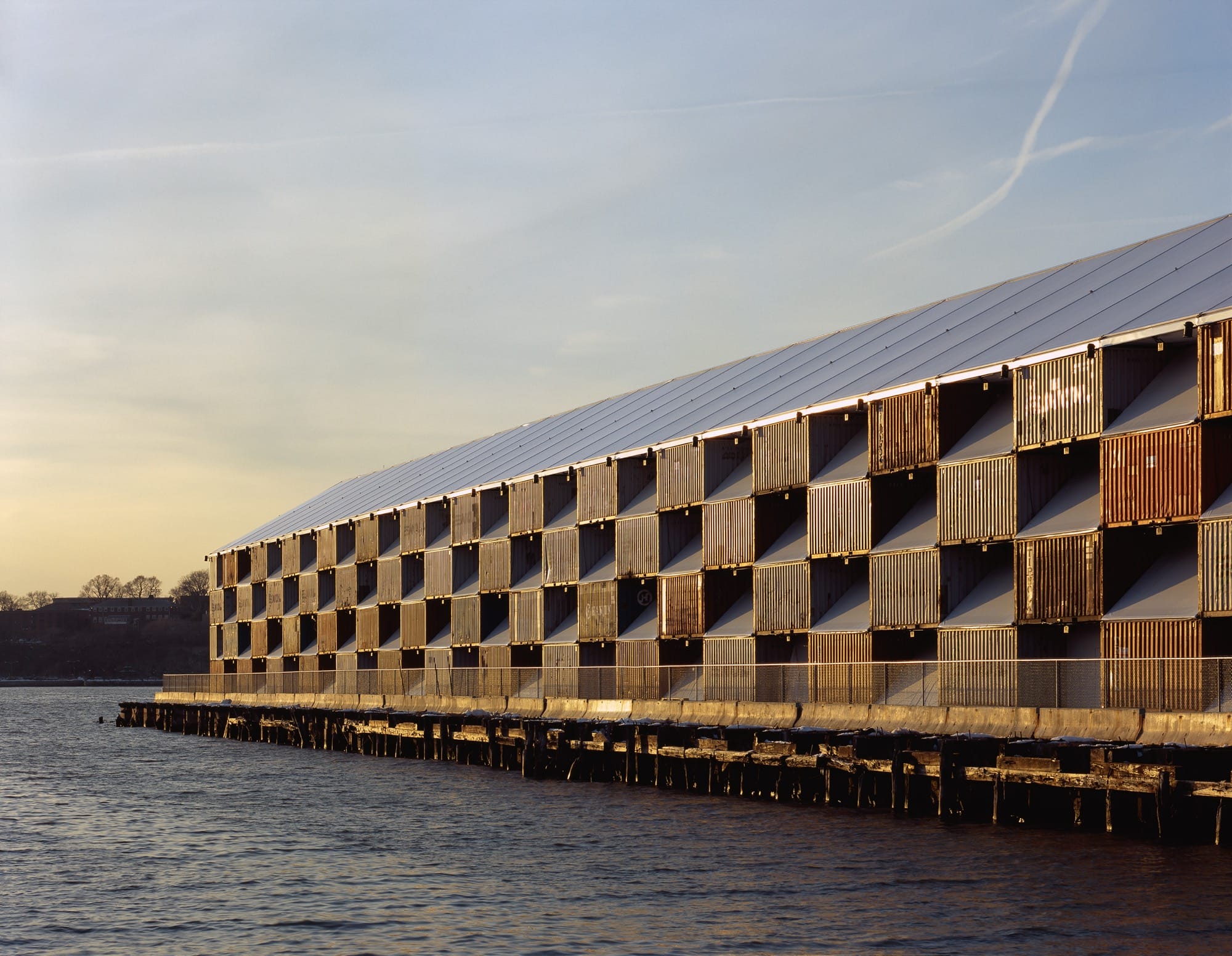 a striking building with a kind of three-dimensional checkerboard effect on a long pier 