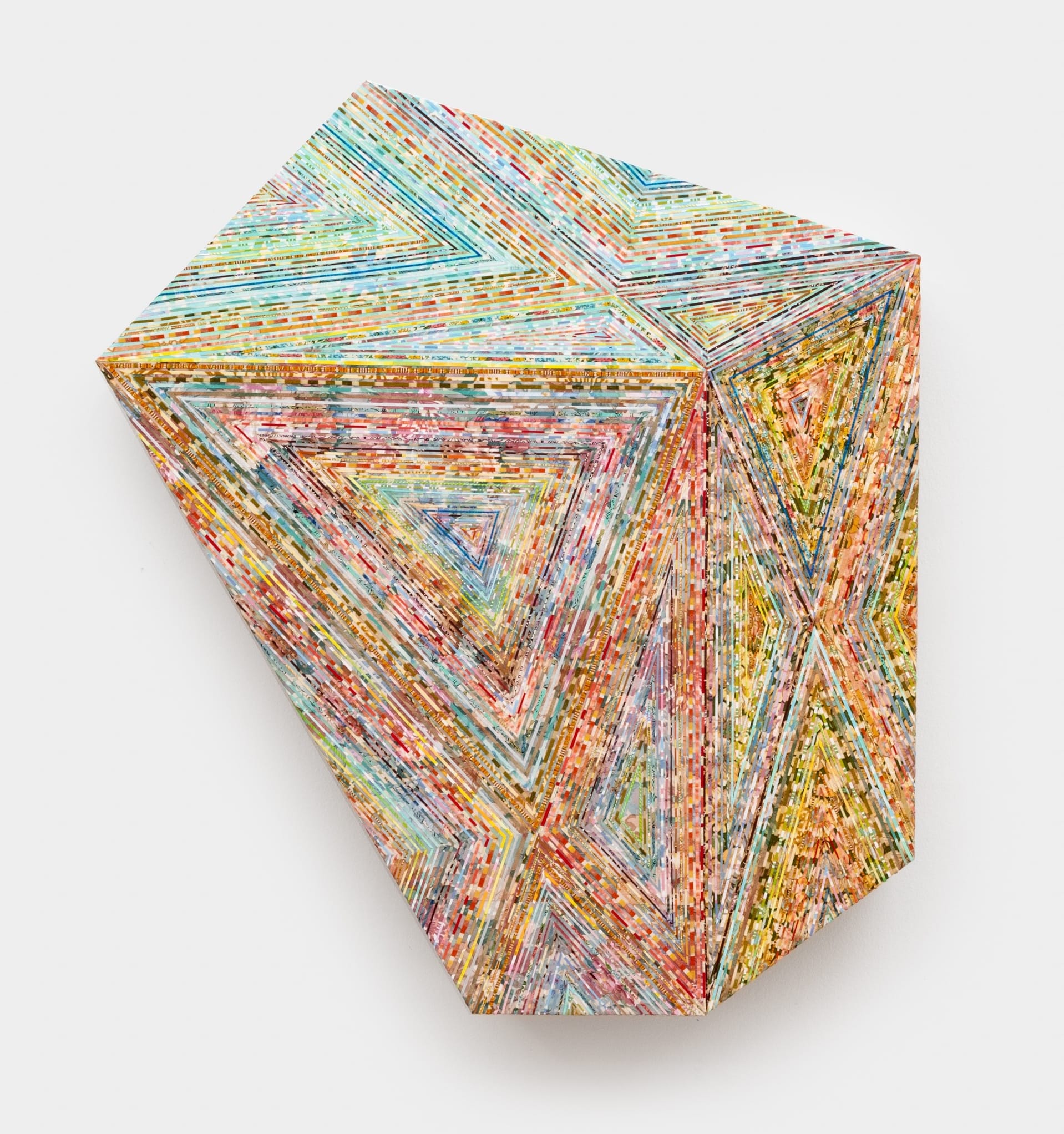 a geometric wall artwork with a deep, shaped panel overlaid with strips of colorful vintage wallpaper in a faceted pattern that plays with perspective and depth
