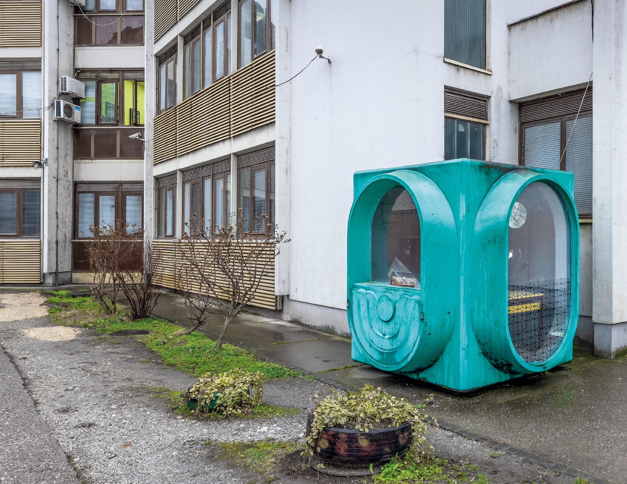 a turquoise, modernist kiosk in on a housing estate in Serbia