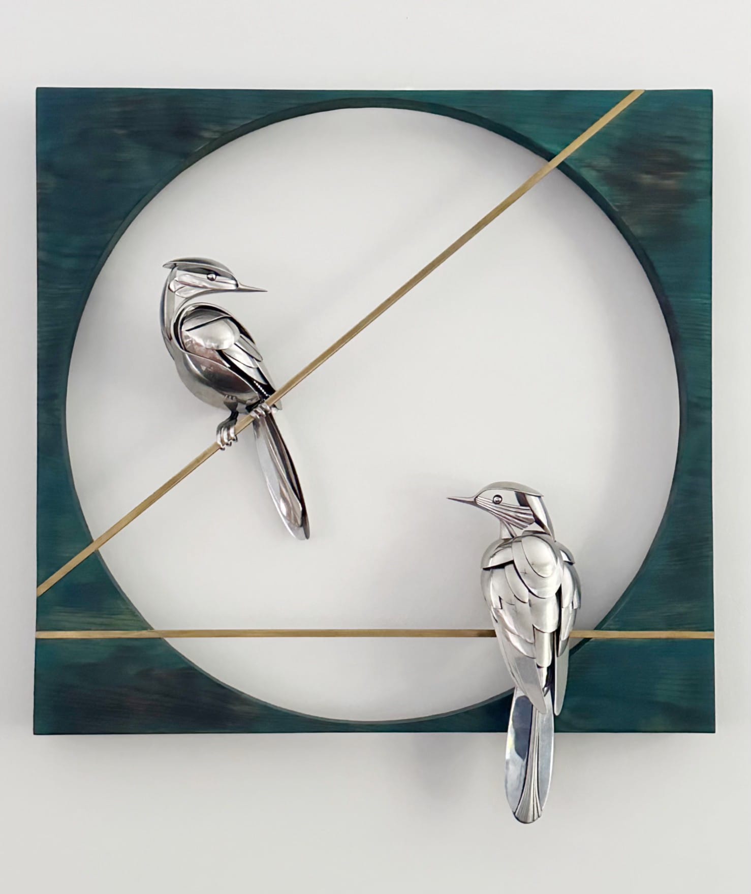 two metal birds are perched upon an angle within a green metal frame