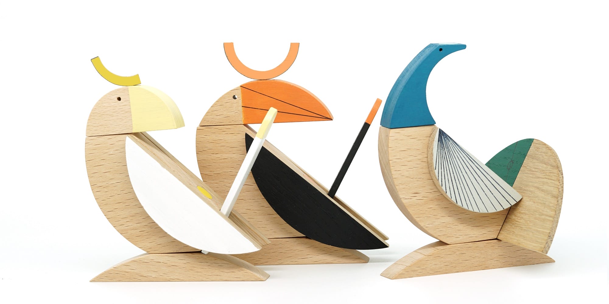 a series of three geometric wooden toys shaped like tropical birds