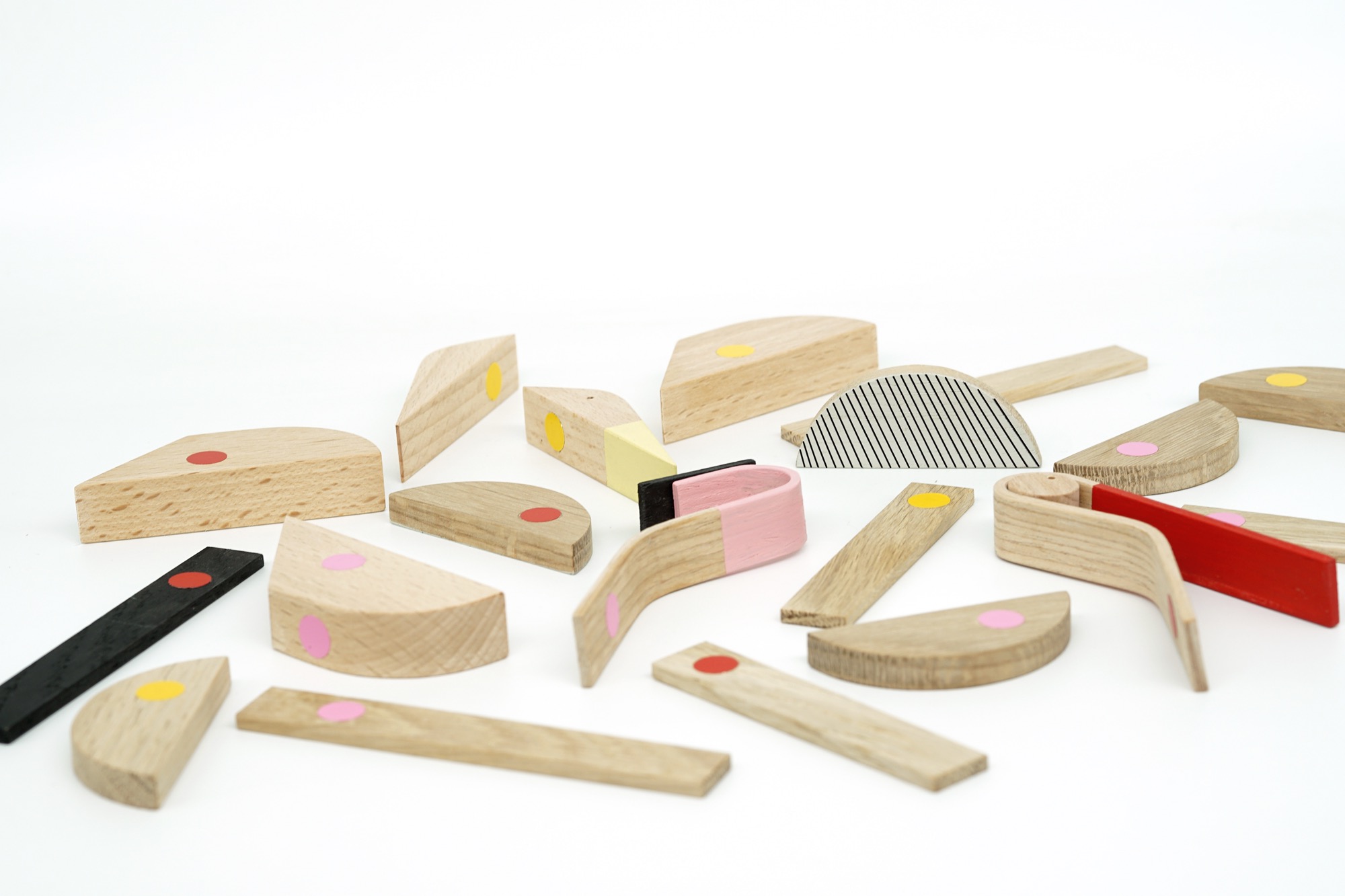 an array of geometric pieces of wood with red magnets that can be assembled into a bird or other creatures