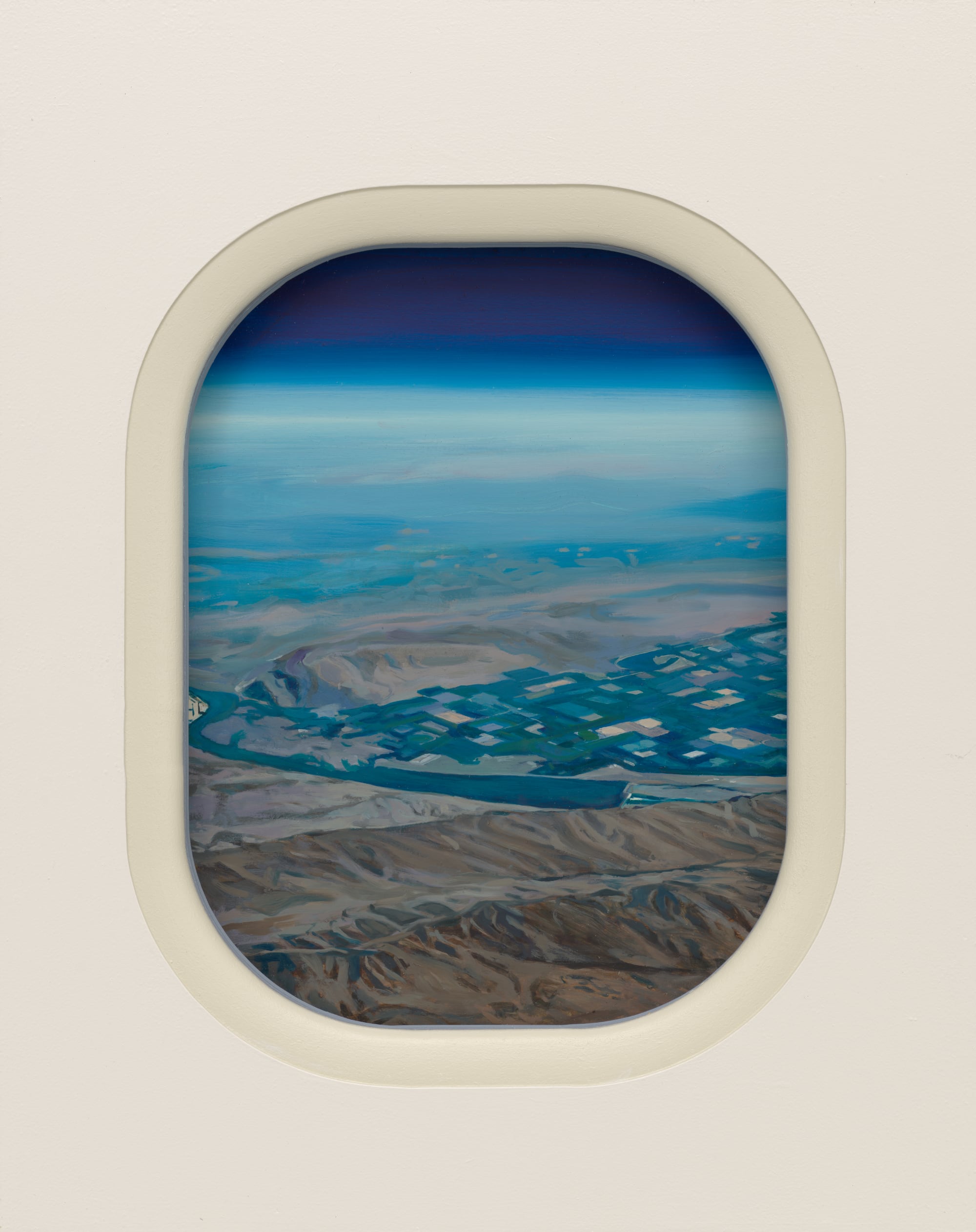 a desert and mountain landscape painting through an airplane-like window