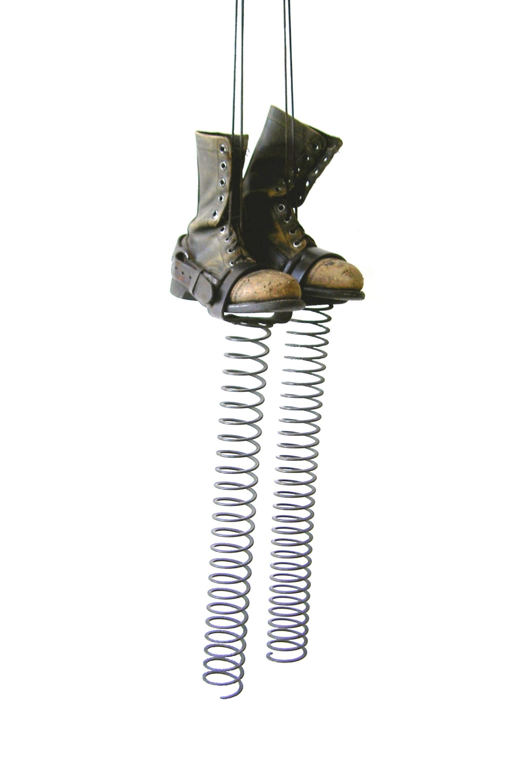 a sculpture of an old pair of military-issue boots with spring contraptions attached to the bottom as if they could be used to bounce very high